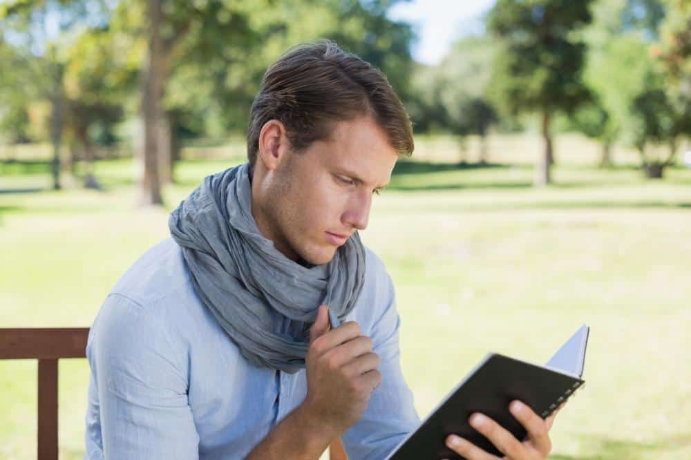 man journaling outdoors