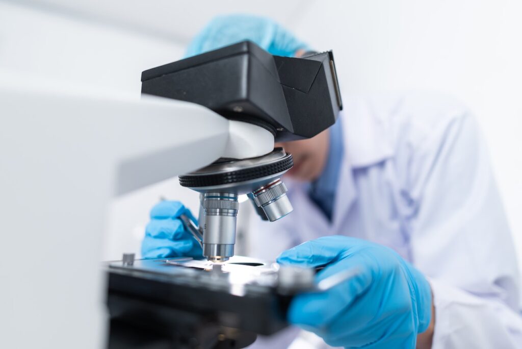 man examining adderall for fentanyl under microscope